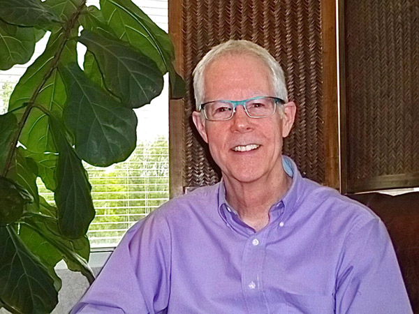 Doug sitting by a plant