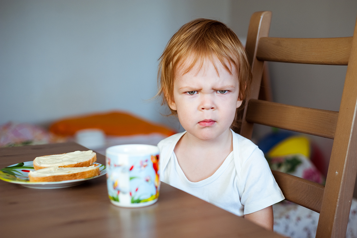 Angry 4 year old girl with red hair looking at camera