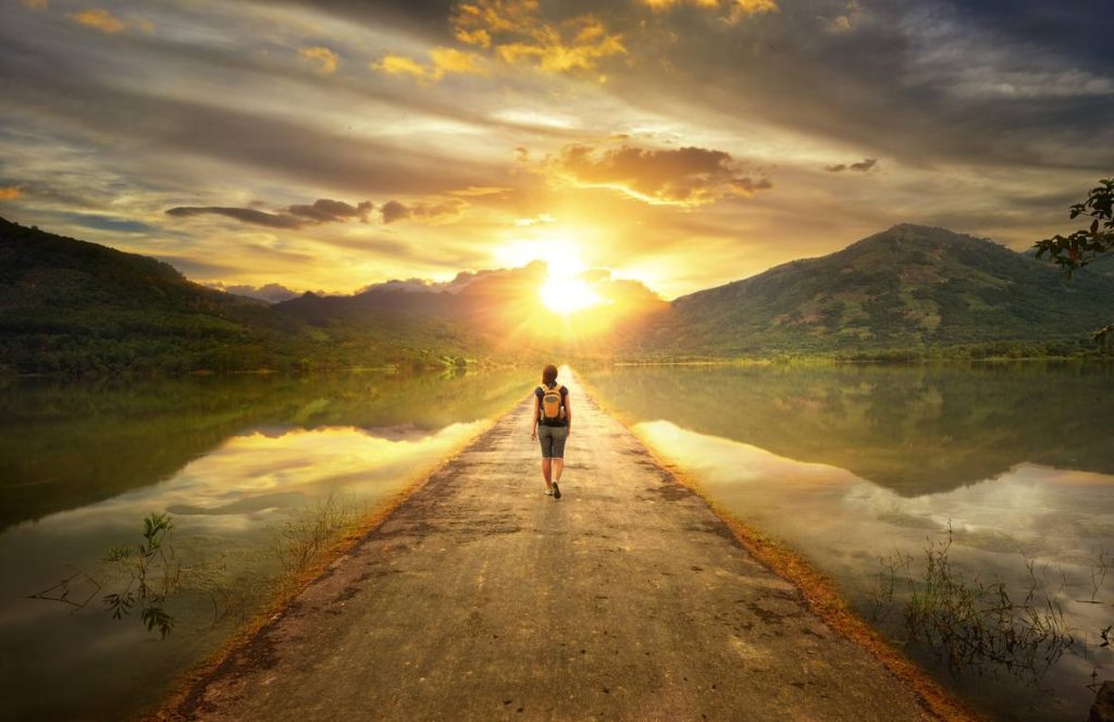 Woman walking down a road through a lake