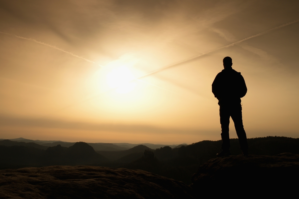 silhouette of person looking at sunrise