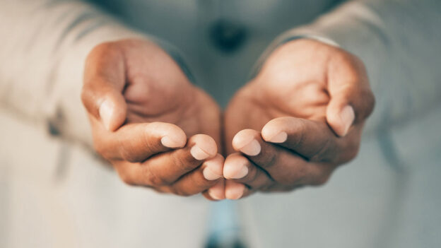 Hands cupped reaching out in a compassionate way