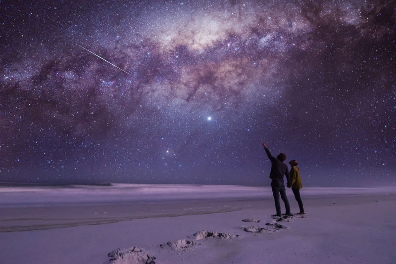 two people looking at milky way